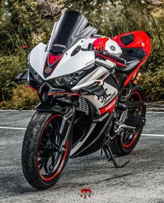 a red and white motorcycle parked on the street