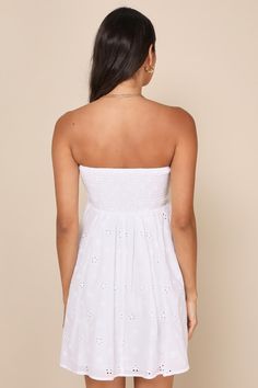 Summer sandals, sunny days, and the Lulus Sweetly Vibing White Eyelet Strapless Tie-Front Mini Dress are a perfect match! Airy woven cotton, with floral-inspired eyelet embroidery throughout, shapes this adorable dress that has a strapless bodice with a sweetheart neckline atop a tie-front bodice with fitted smocking at the back. Cutout detail tops a high waist that continues into a flaring skirt with a mini hem. Fit: This garment fits true to size. Length: Mid-thigh. Size medium measures 26.75" Feminine Strapless Sundress For Spring, Feminine Cotton Sundress For Summer, Summer Style Sundress For Spring Outings, Summer Style Sundress For Outings, Spring Bandeau Fitted Sundress, Breezy Cotton Sundress For Brunch, Cotton Sundress For Summer Day Out, Fitted Bandeau Sundress For Summer, Fitted Strapless Sundress For Summer