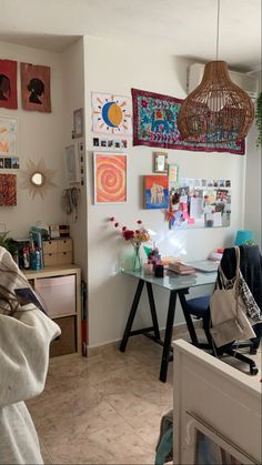 a living room filled with furniture and pictures on the wall next to a table in front of a window