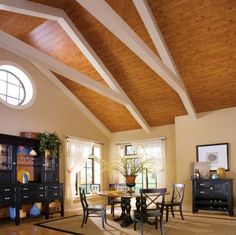 a dining room filled with furniture and a large window covered in wood planks on the ceiling