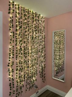 there is a mirror and some plants on the wall in this room with pink walls