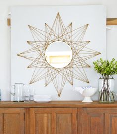 a large star decoration on the wall above a buffet table with vases and glasses