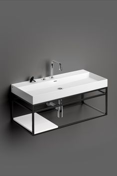 a white sink sitting on top of a counter next to a wall mounted faucet