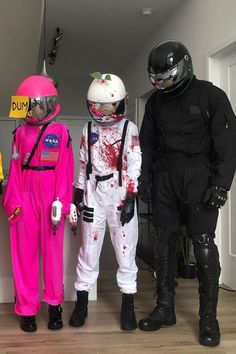 three people dressed in costumes and helmets standing next to each other on a hard wood floor