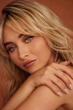 a woman with blonde hair and blue eyes is posing for a magazine cover photo wearing a gold ring