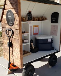 a small wooden shed with wheels and shelves