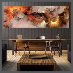 an abstract painting hangs on the wall above a wooden table in a modern dining room