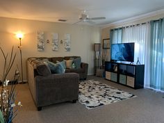 a living room filled with furniture and a flat screen tv