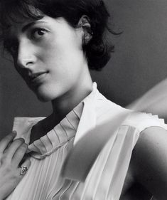 a black and white photo of a woman adjusting her tie