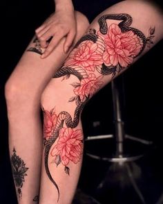 a woman's legs with tattoos and flowers on them