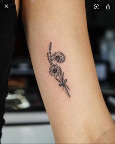 a woman's arm with daisies and clover tattoo on the left inner arm