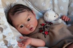 a baby laying in a crib with a stuffed animal