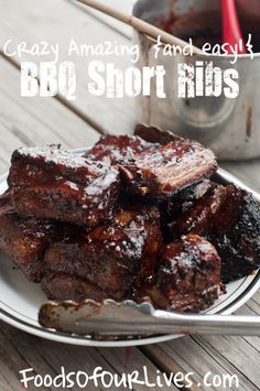 a white plate topped with ribs covered in bbq sauce