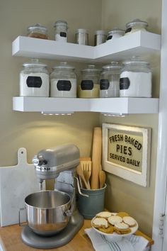 a kitchen shelf filled with lots of food and cooking utensils on top of a wooden counter