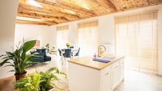 a kitchen and living room with wooden ceilings