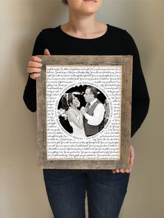 a woman holding up a framed photo in front of her face with the words on it