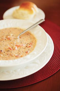 a white bowl filled with soup on top of a red place mat