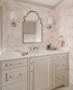 a bathroom with pink and white wallpaper, two sinks and a mirror on the wall