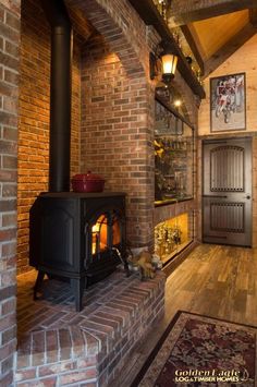 a wood burning stove sitting inside of a living room next to a wooden flooring