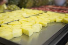 there are many pieces of pineapple on the conveyor belt