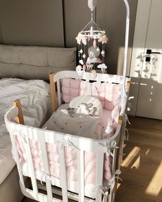 a white crib with a pink blanket on it