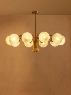 a chandelier hanging from the ceiling in a room with beige walls and flooring