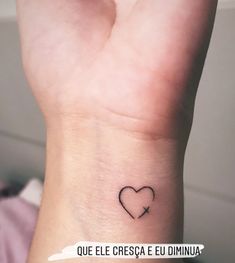 a small heart tattoo on the wrist