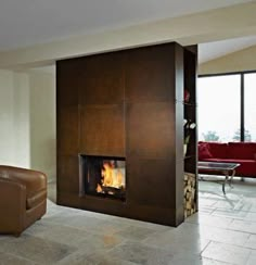 a living room with a fire place next to a couch and chair in front of a large window