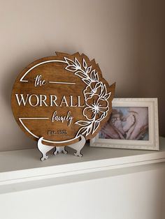 a wooden plaque with the words, the worraly family on it next to a photo frame