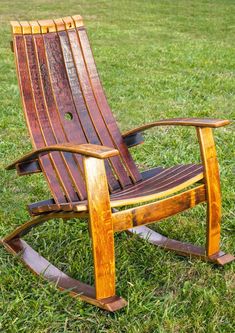 a wooden rocking chair sitting in the grass