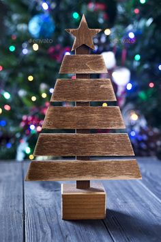 a wooden christmas tree on a table with lights in the background - stock photo - images