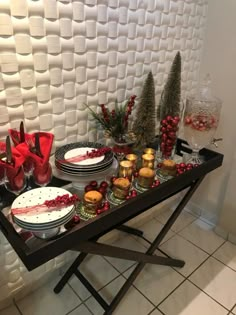 the table is set with plates, silverware and red bows on it's head