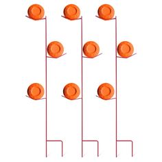 several orange plates are arranged on red metal poles and stand against a white background with shadows