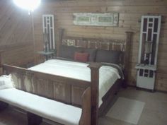 a wooden bed sitting inside of a bedroom next to a window