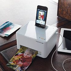 a cell phone is sitting on top of a printer that's plugged in