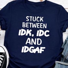 a t - shirt that says stuck between idk, idc and dgaf