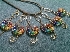 a necklace with multicolored beads hanging from it's side on a gray surface