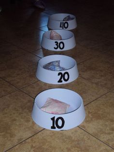 three white bowls with numbers in them sitting on the floor