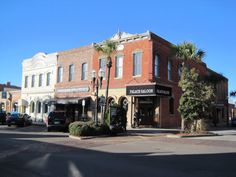 an old brick building with palm trees on the corner