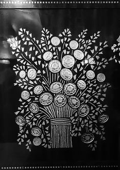 a black and white photo of a vase with flowers