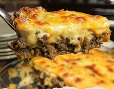 a piece of lasagna being lifted from a casserole dish by a fork