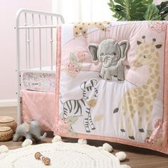 a baby crib bedding set with an elephant and giraffe theme