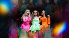 three beautiful women standing next to each other in front of an audience with bright lights