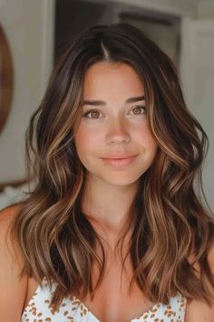 Smiling woman with wavy brown hair and a gentle expression. Coppery Brown Hair Caramel Highlights, Brown Hair With Red And Caramel Highlights, Light Auburn Highlights In Brown Hair, Caramel Highlights In Brown Hair, Warm Brown With Blonde Highlights, Brown Hair With Highlights And Layers, Honey Caramel Highlights On Brown Hair, Caramel Highlights On Light Brown Hair, Brown Hair Balyage