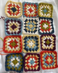 crocheted squares are arranged on a white surface