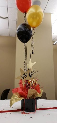 balloons and streamers are in the shape of stars on top of a black bucket