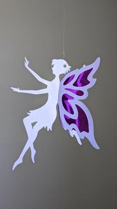 a purple and white tinkerbell hanging from a string