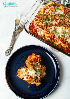 a blue plate topped with lasagna casserole next to a baking dish