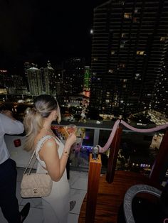 a woman standing on top of a building at night