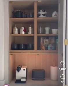 the coffee maker is sitting on the shelf in the kitchen cabinet with its lid open